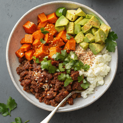 Meal prep containers filled with High Protein Beef & Sweet Potato Bowl ingredients including avocado and cottage cheese